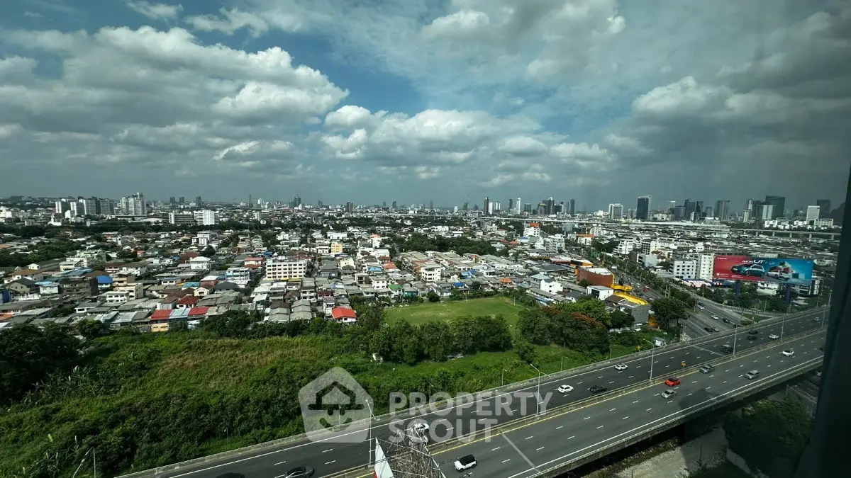 Stunning cityscape view from high-rise building with expansive skyline and lush greenery.