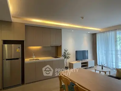 Modern open-layout kitchen and living room with sleek design and natural light.