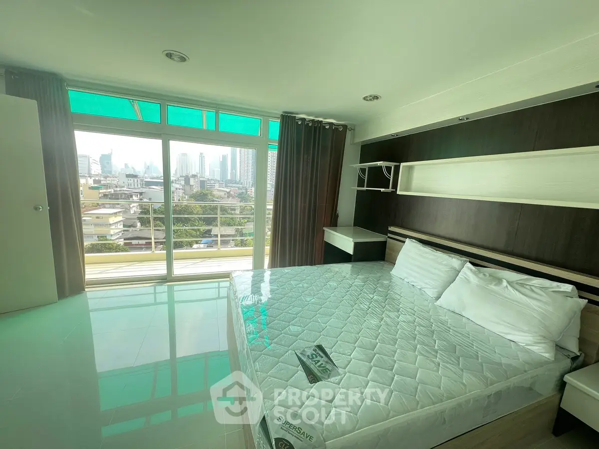 Spacious bedroom with city view and modern design in high-rise apartment