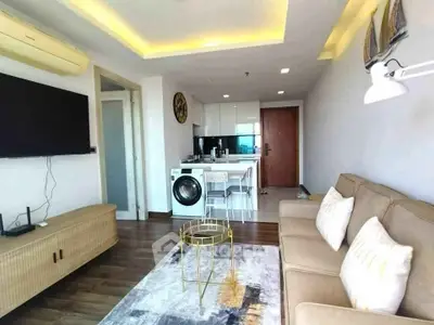 Modern living room with open kitchen and washing machine, featuring stylish decor and cozy seating.