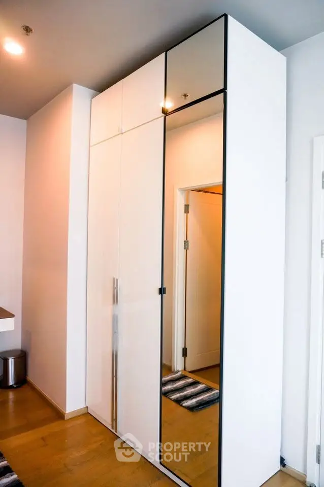 Modern interior with sleek mirrored wardrobe and wooden flooring