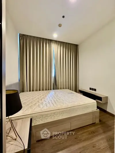 Modern bedroom with elegant decor and natural light, featuring a comfortable bed and stylish furnishings.