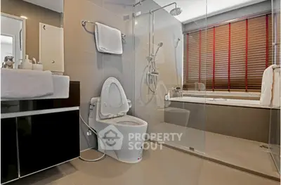 Modern bathroom with glass shower and bathtub in luxury apartment