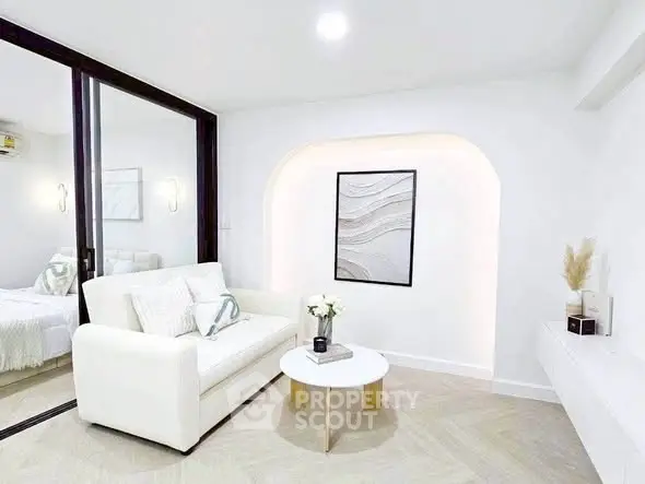 Modern living room with white sofa, stylish decor, and elegant lighting