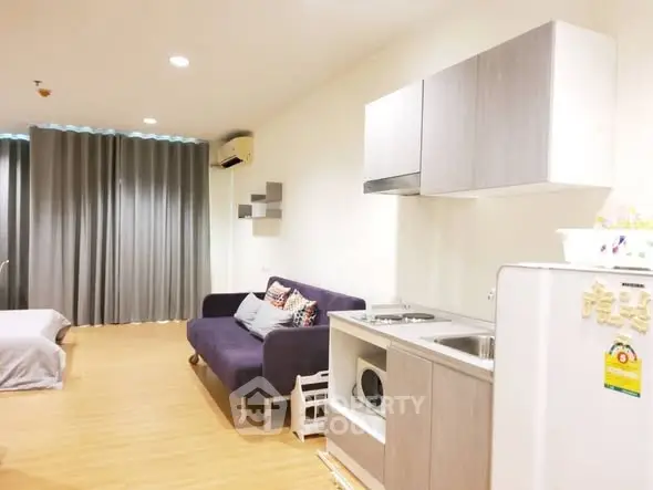 Modern studio apartment with cozy living area and compact kitchen