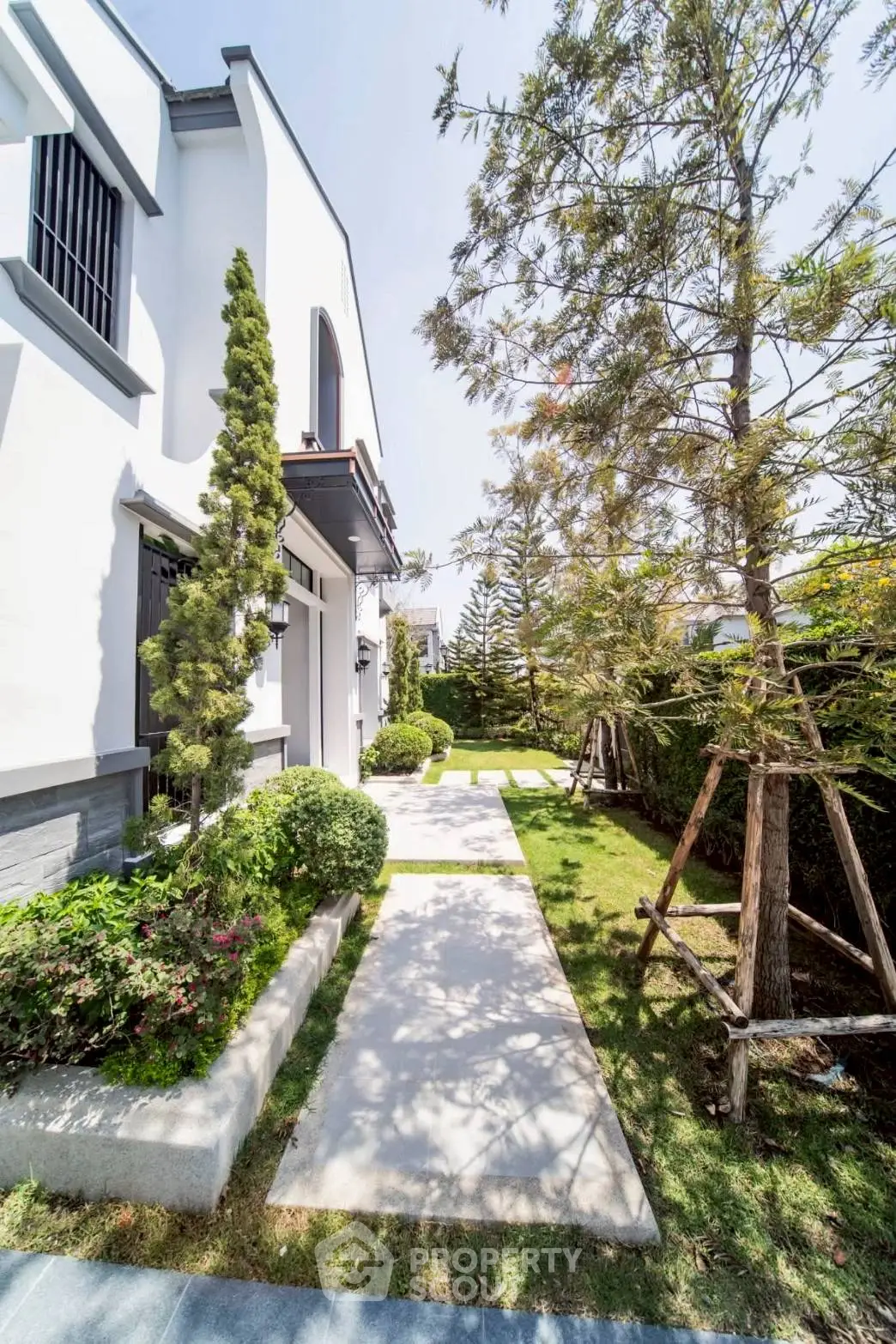 Charming modern house exterior with lush garden and pathway, perfect for serene living.