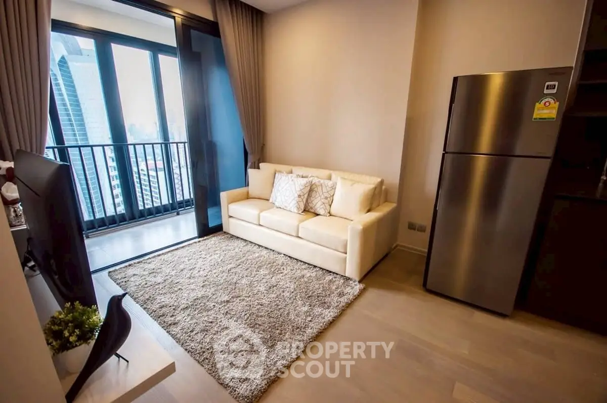 Modern living room with city view, cozy sofa, and sleek refrigerator in a high-rise apartment.