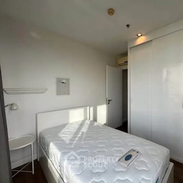 Cozy bedroom with single bed and built-in wardrobe, perfect for minimalist living.