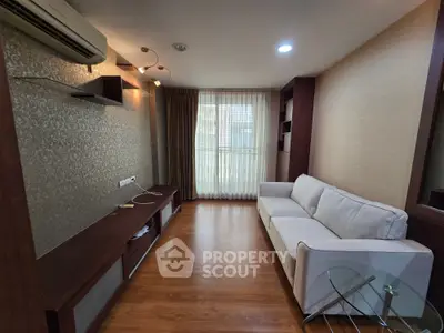 Modern living room with elegant decor and natural light, featuring a comfortable sofa and stylish wooden flooring.