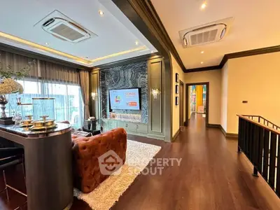 Luxurious living room with elegant decor and modern lighting, featuring a plush sofa and large TV.