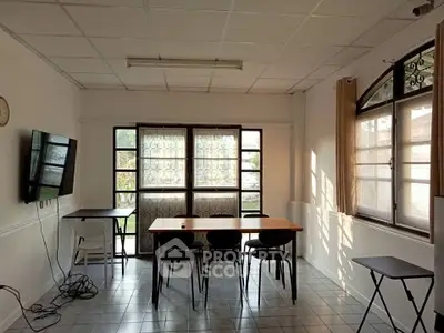 Bright and airy room with large windows and modern furnishings, perfect for a home office or study area.