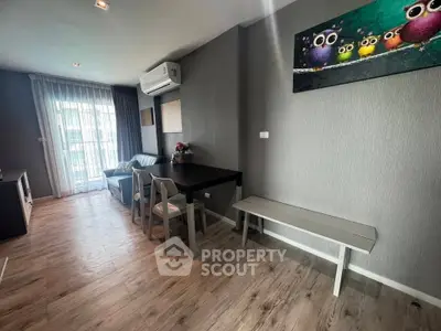 Modern living room with stylish decor and natural light, featuring a cozy seating area and contemporary artwork.