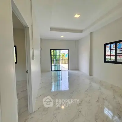 Spacious modern room with marble flooring and large windows for natural light.