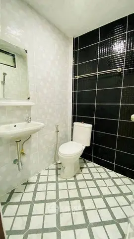 Modern bathroom with black and white tile design and sleek fixtures.