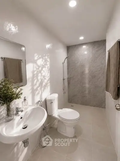 Modern bathroom with sleek fixtures and elegant tile design, featuring a spacious shower area.