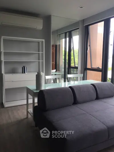 Modern living room with large windows and stylish furniture in a contemporary apartment.