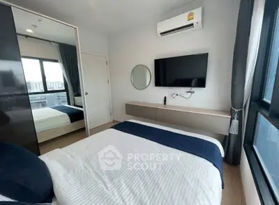 Modern bedroom with sleek design, featuring a wall-mounted TV and large windows for natural light.