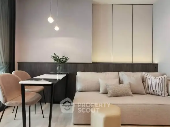 Modern living room with elegant sofa and dining area, featuring stylish lighting and minimalist decor.