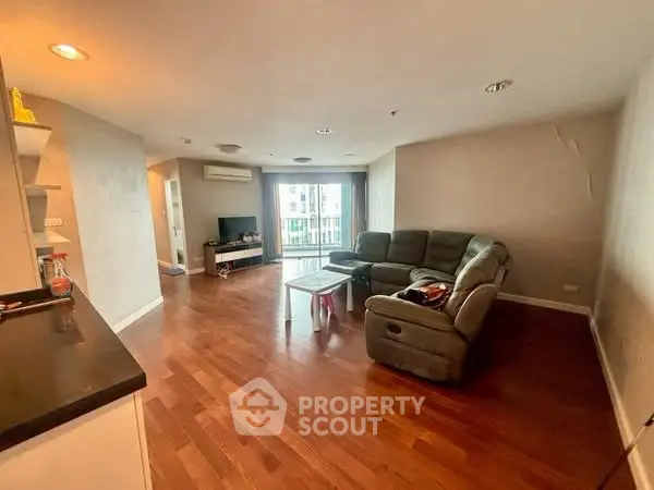 Spacious living room with wooden flooring and modern furniture, ideal for family gatherings.