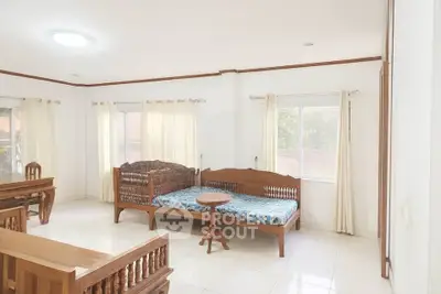 Spacious living room with wooden furniture and large windows
