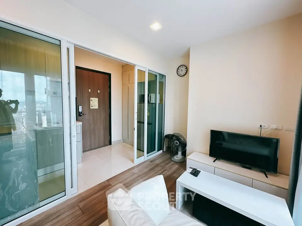Modern living room with sleek furniture and large glass doors in a stylish apartment.