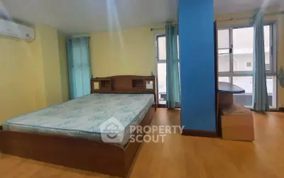 Spacious bedroom with large windows and wooden flooring