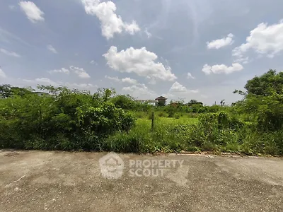 Expansive vacant land with lush greenery under a clear blue sky, perfect for development opportunities.