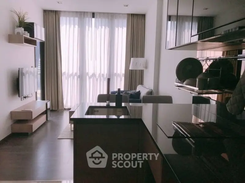 Modern open-layout living room with sleek kitchen and floor-to-ceiling windows.
