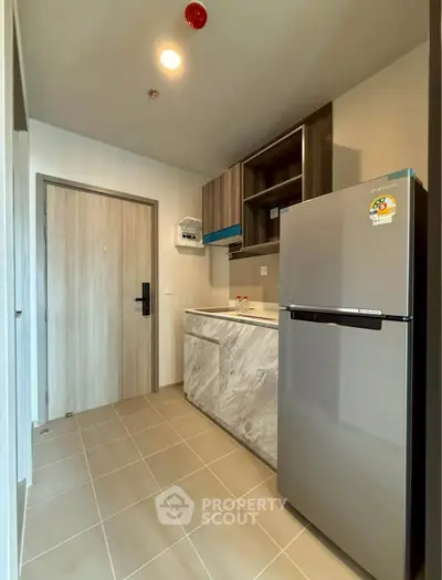 Modern kitchen with sleek appliances and stylish cabinetry in a compact layout.