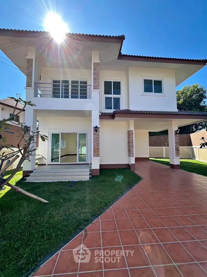 Stunning two-story house with spacious driveway and lush green lawn under a clear blue sky.