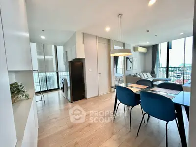 Modern open-plan living and dining area with sleek furnishings and natural light.