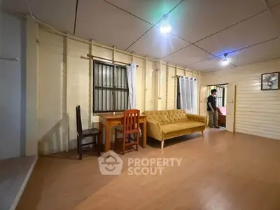 Spacious living room with cozy sofa and wooden furniture in a charming home.