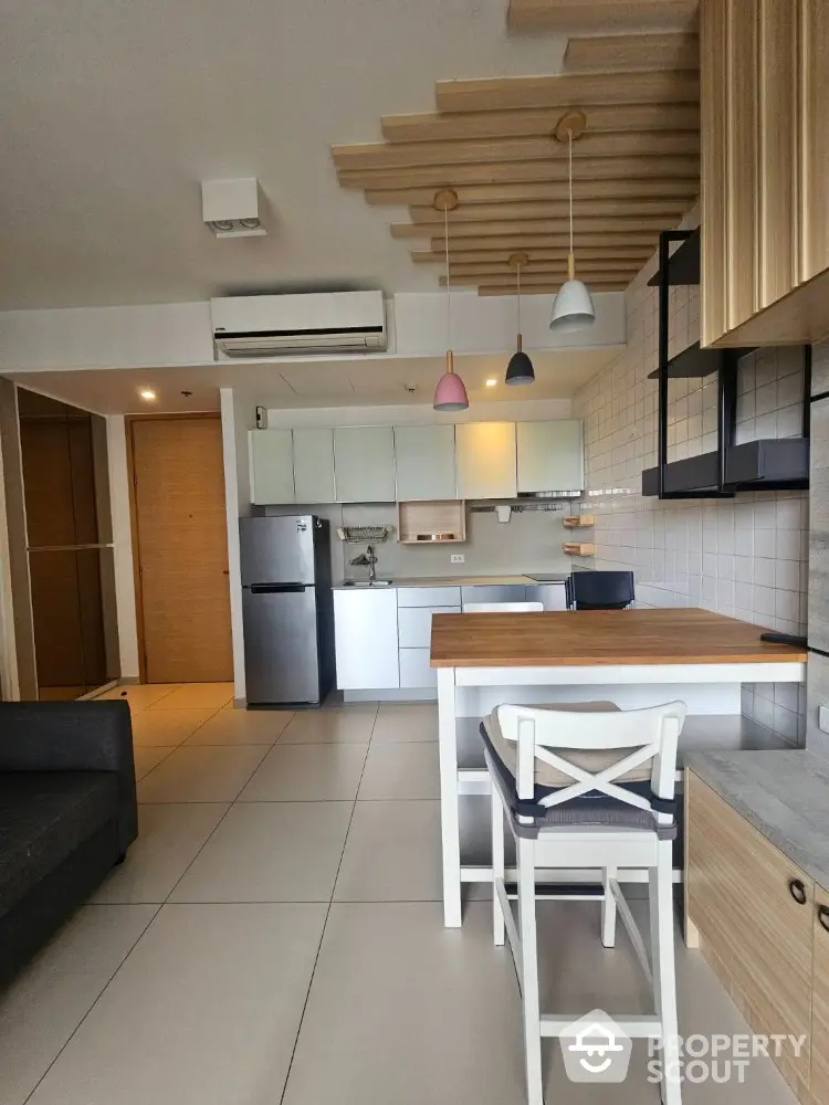 Modern kitchen with stylish pendant lights and sleek appliances in open layout