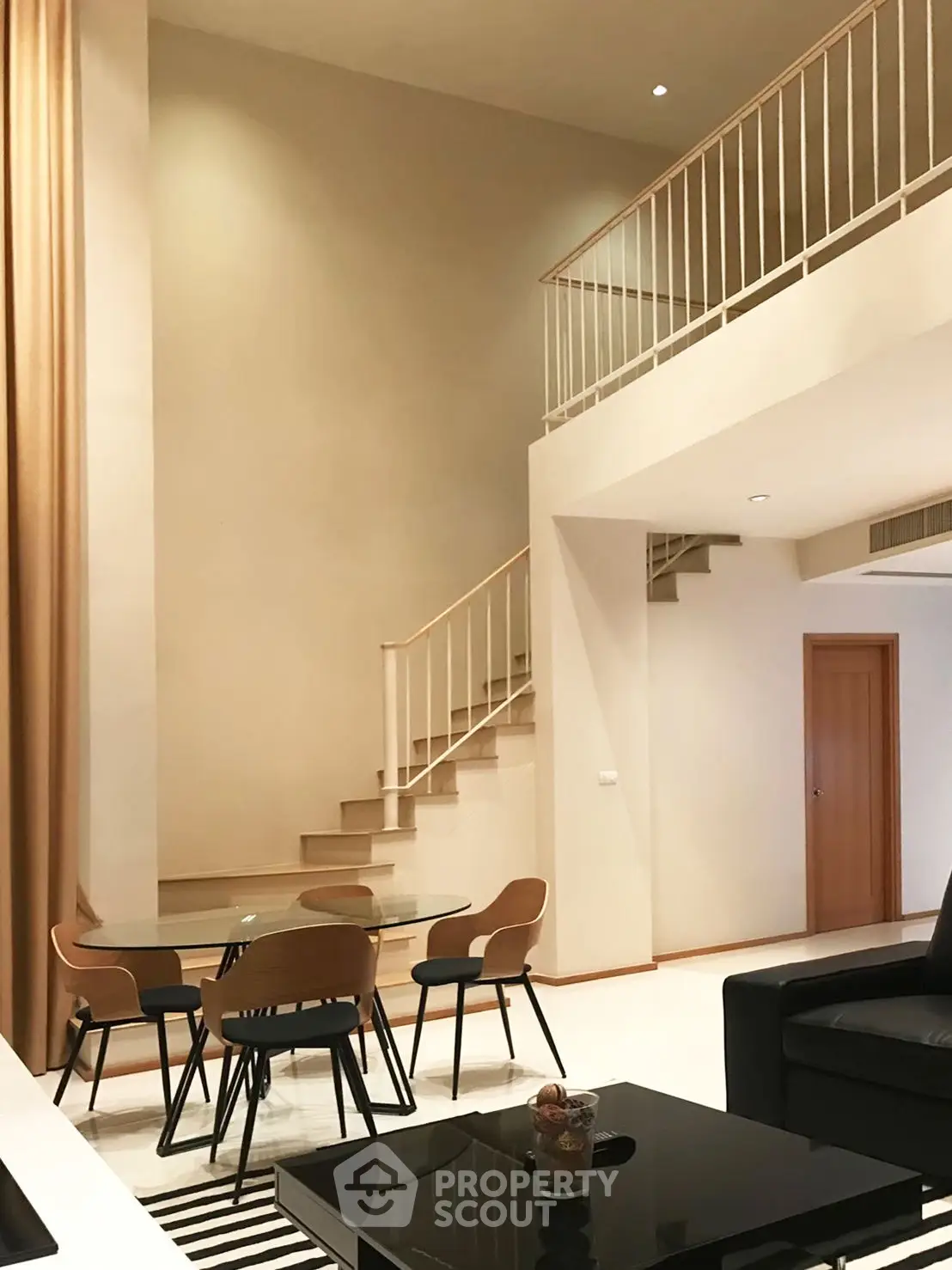 Spacious modern living room with high ceilings and elegant staircase