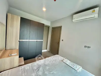 Modern bedroom with sleek wardrobe and air conditioning in a stylish apartment.