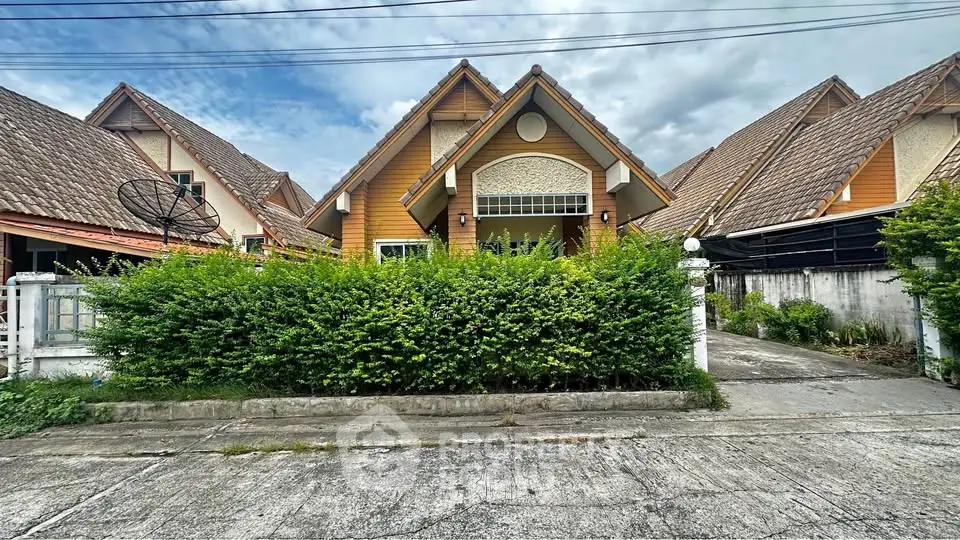 Charming suburban house with lush greenery and unique architectural design.