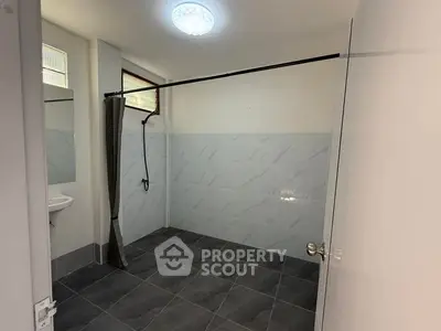 Spacious modern bathroom with sleek tile design and open shower area.