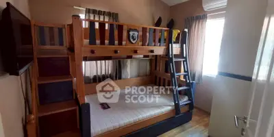 Cozy bedroom with wooden bunk bed and natural light, perfect for kids or guests.