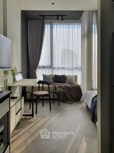 Modern studio apartment with elegant decor and large windows offering ample natural light.