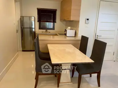 Modern kitchen with dining area, featuring sleek appliances and stylish furniture.