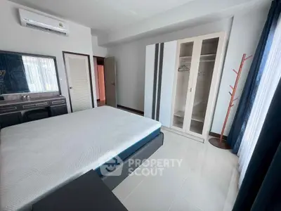 Spacious bedroom with modern furnishings and ample natural light