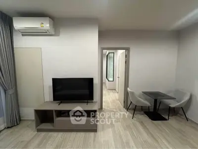 Modern living room with sleek TV stand and cozy dining area, perfect for urban living.