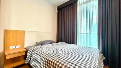 Cozy bedroom with checkered bedding and large window with curtains