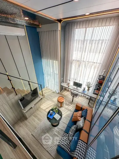 Luxurious modern living room with high ceilings and stylish decor in a duplex apartment.