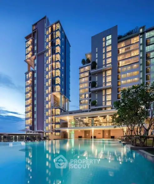 Luxurious high-rise building with stunning pool and modern architecture at dusk.