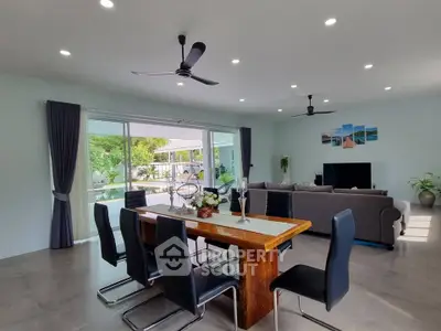 Spacious modern living room with dining area and pool view, perfect for entertaining.