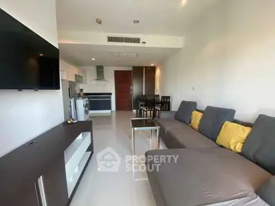 Modern living room with sleek furniture and open kitchen layout in a stylish apartment.