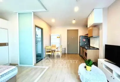 Modern open-plan studio apartment with stylish kitchen and cozy living area.