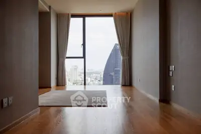 Spacious modern living room with stunning city view and hardwood floors.