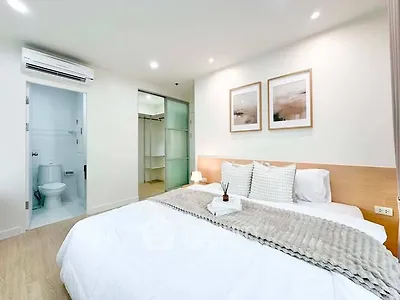 Modern bedroom with ensuite bathroom, featuring cozy decor and soft lighting for a relaxing ambiance.